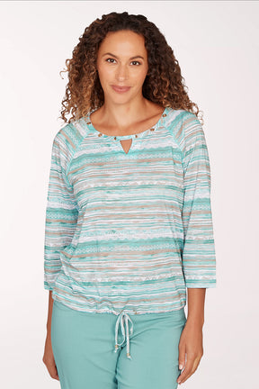 Woman wearing a striped long-sleeve top and light blue pants on a white background