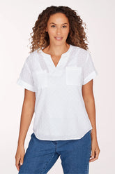 Woman wearing a white blouse with short sleeves and blue jeans on a white background