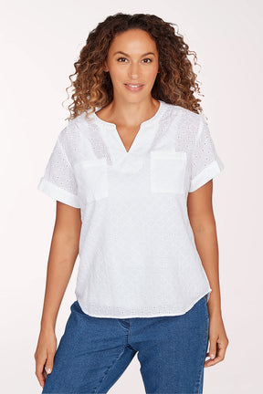 Woman wearing a white blouse with short sleeves and blue jeans on a white background