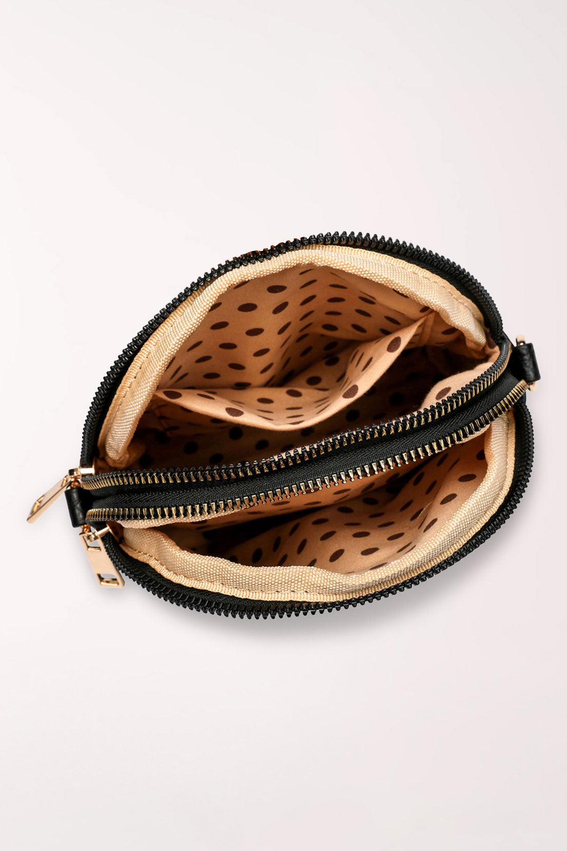 Top view of the black 22 Tote Four-Pocket Crossbody Bag with both zippers open, showing two compartments lined in tan with brown polka dots.