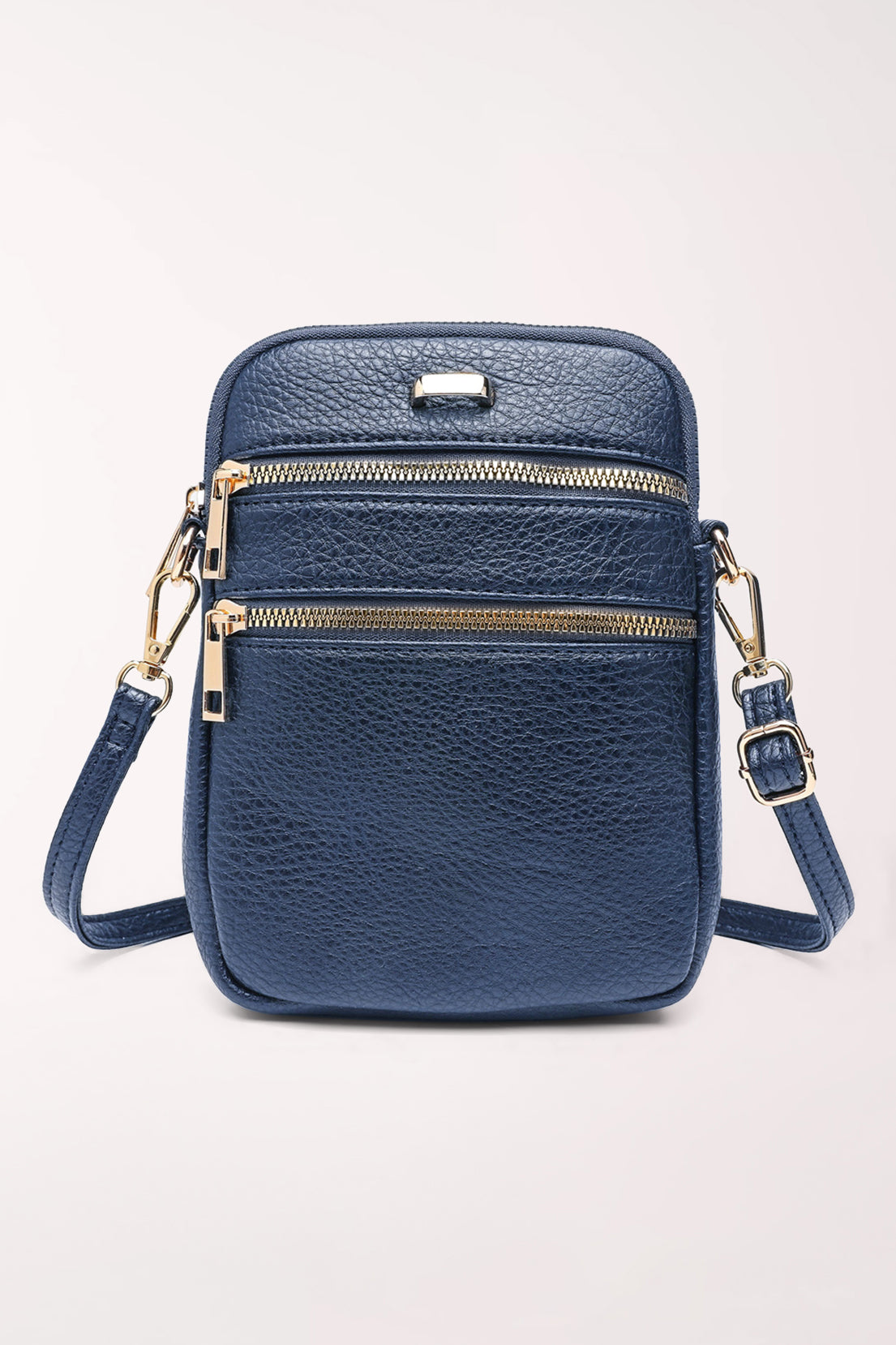 Front view of the 22 Tote Three-Pocket Crossbody Bag in navy pebbled faux leather: a small upright bag with two horizontal zippered pockets across the front, gold zippers and hardware, and an adjustable crossbody strap.