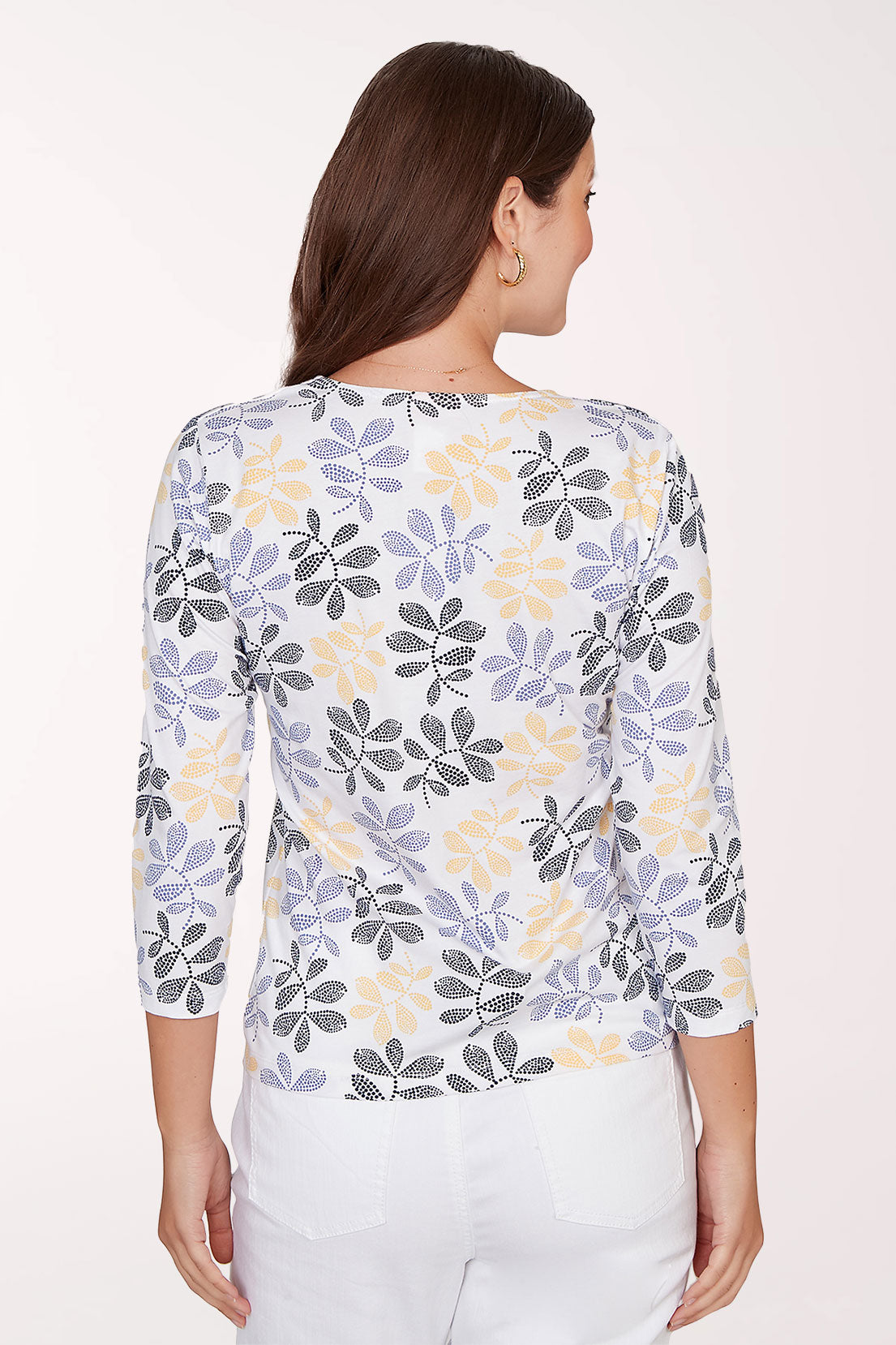 Woman wearing a floral-patterned shirt with a plain background