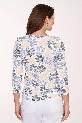 Woman wearing a floral-patterned shirt with a plain background