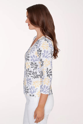 Woman wearing a floral-patterned shirt with a plain background