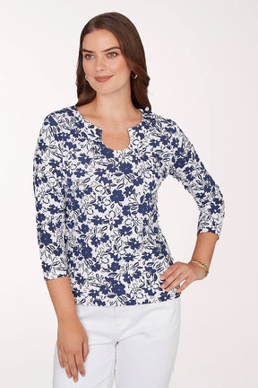 Woman wearing a blue floral patterned top on a white background