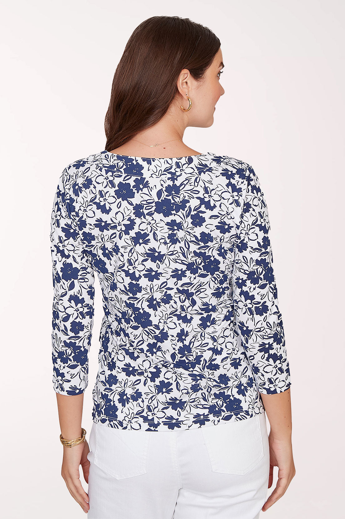 Woman wearing a blue floral patterned top on a white background