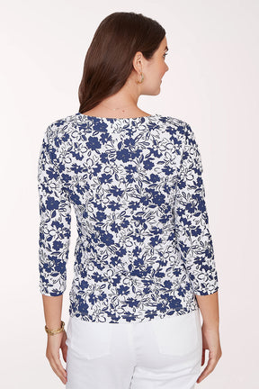 Woman wearing a blue floral patterned top on a white background