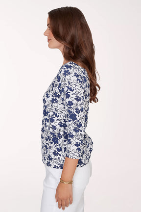 Woman wearing a blue floral patterned top on a white background