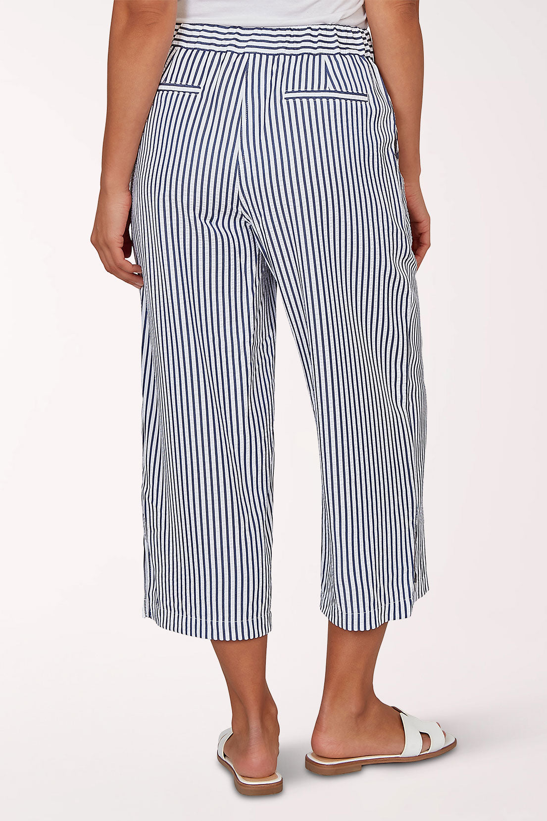 Woman wearing a seersucker navy and white crop pant.
