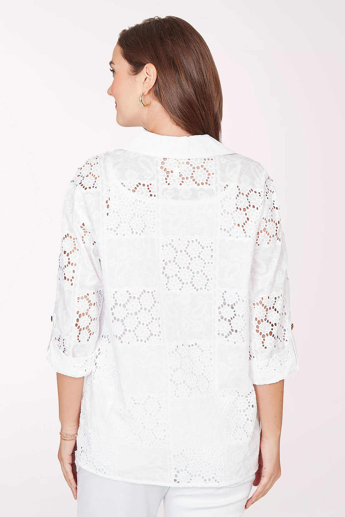 Woman wearing a 3/4 sleeve button-up white top.