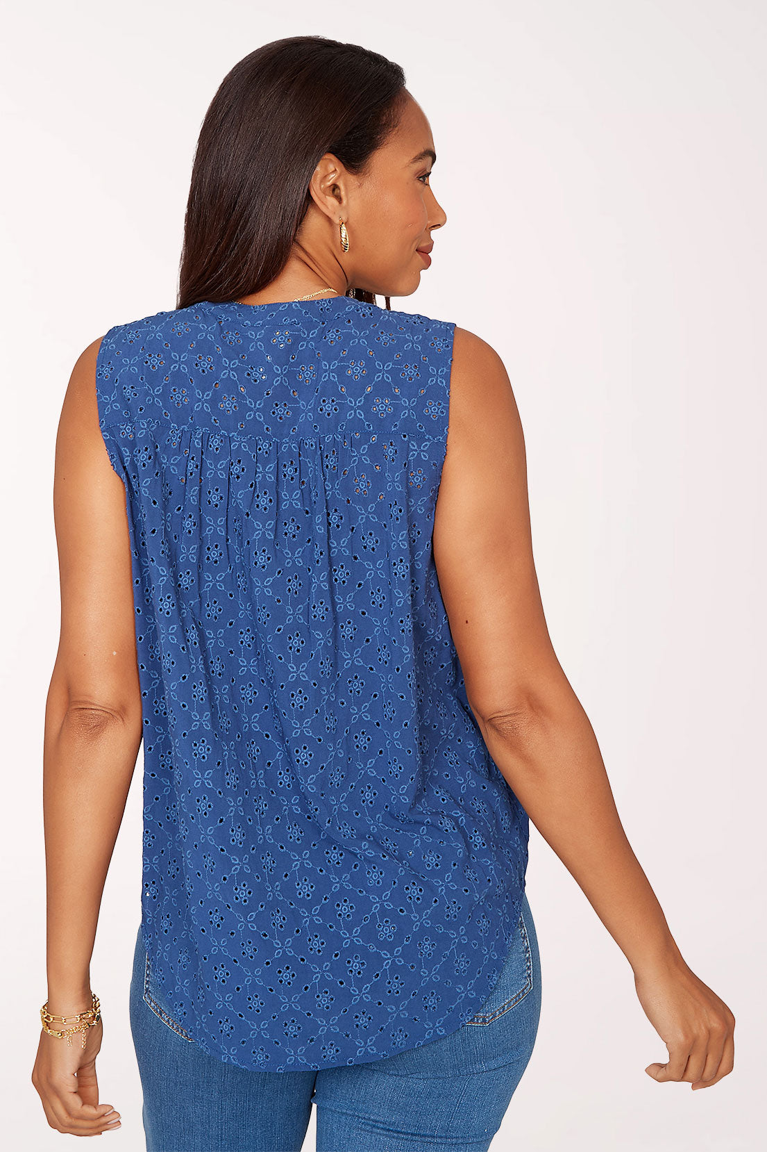 Woman wearing a sleeveless blue top.