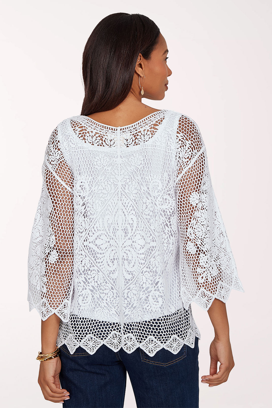 Woman wearing a white crochet top.