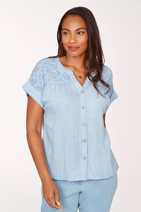 Woman wearing a short sleeve blue top.