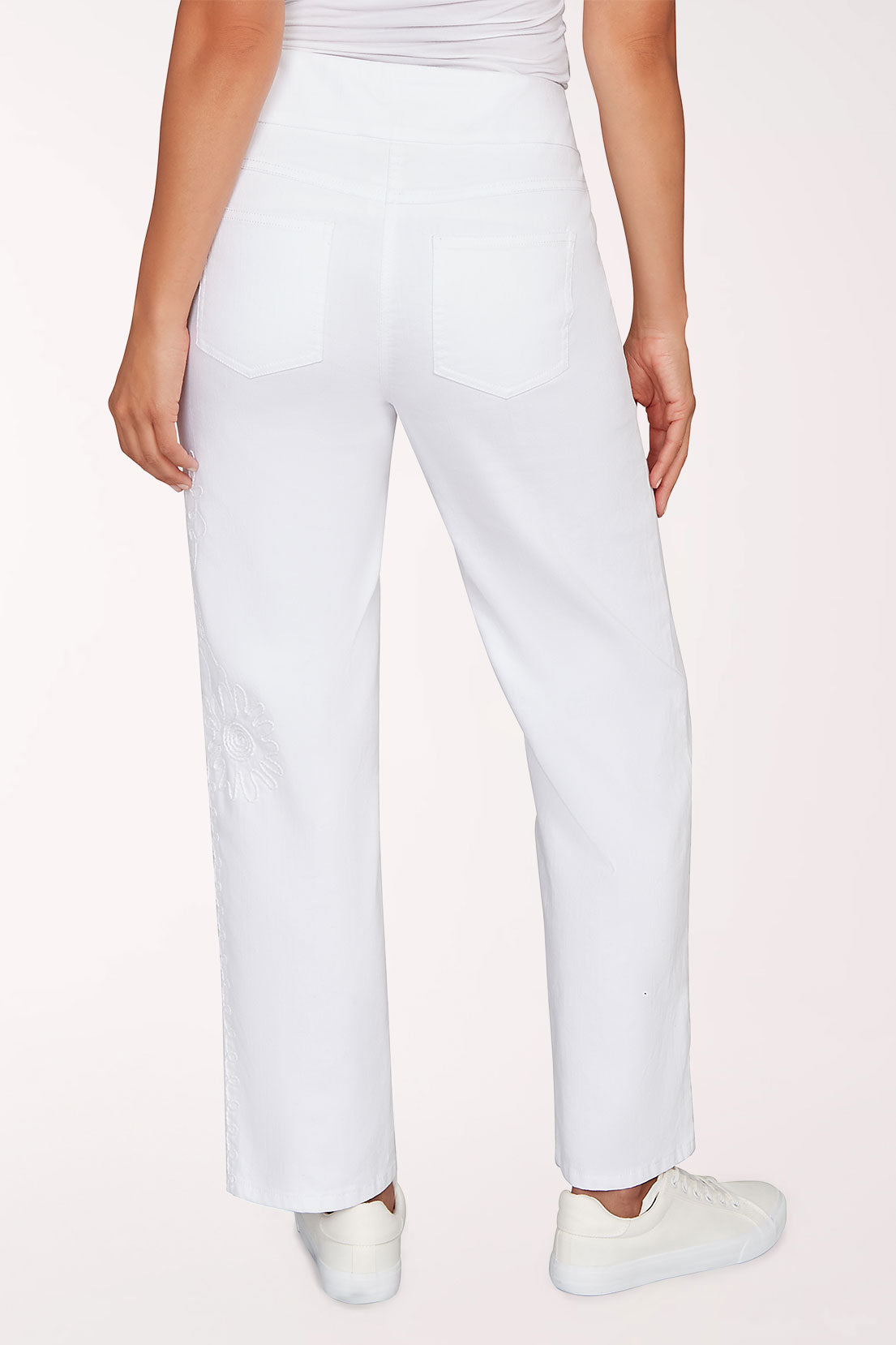 White pants worn by a person on a light pink background