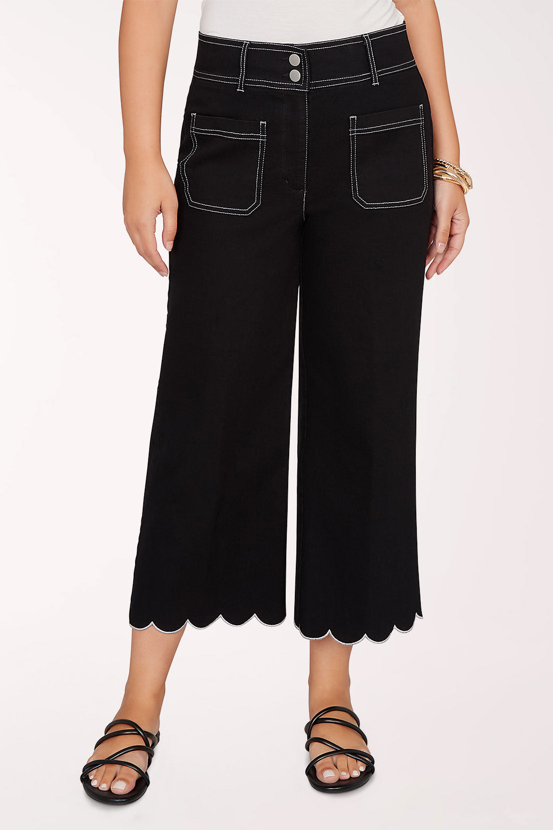 Person wearing black scalloped pants on a white background