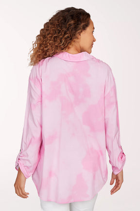 Woman wearing a pink floral blouse against a white background