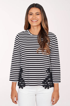 Woman wearing a black and white striped sweater with lace details on a white background