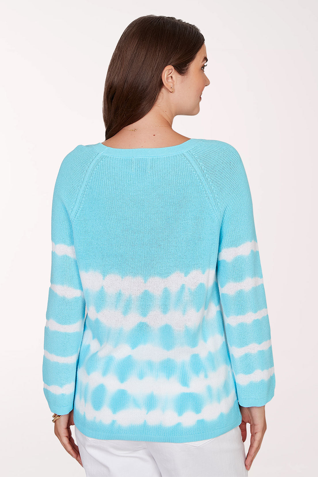 Woman wearing a blue and white tie-dye sweater on a white background