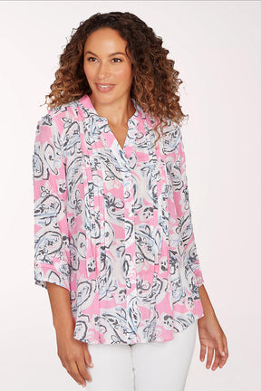 Woman wearing a pink and white patterned blouse on a white background