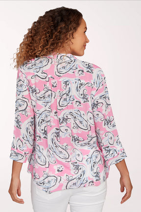 Woman wearing a pink and white patterned blouse on a white background