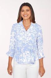 Woman wearing a light blue and white patterned blouse on a white background