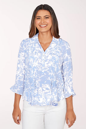 Woman wearing a light blue and white patterned blouse on a white background