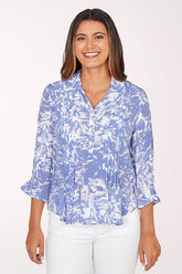 Woman wearing a blue and white patterned blouse on a white background