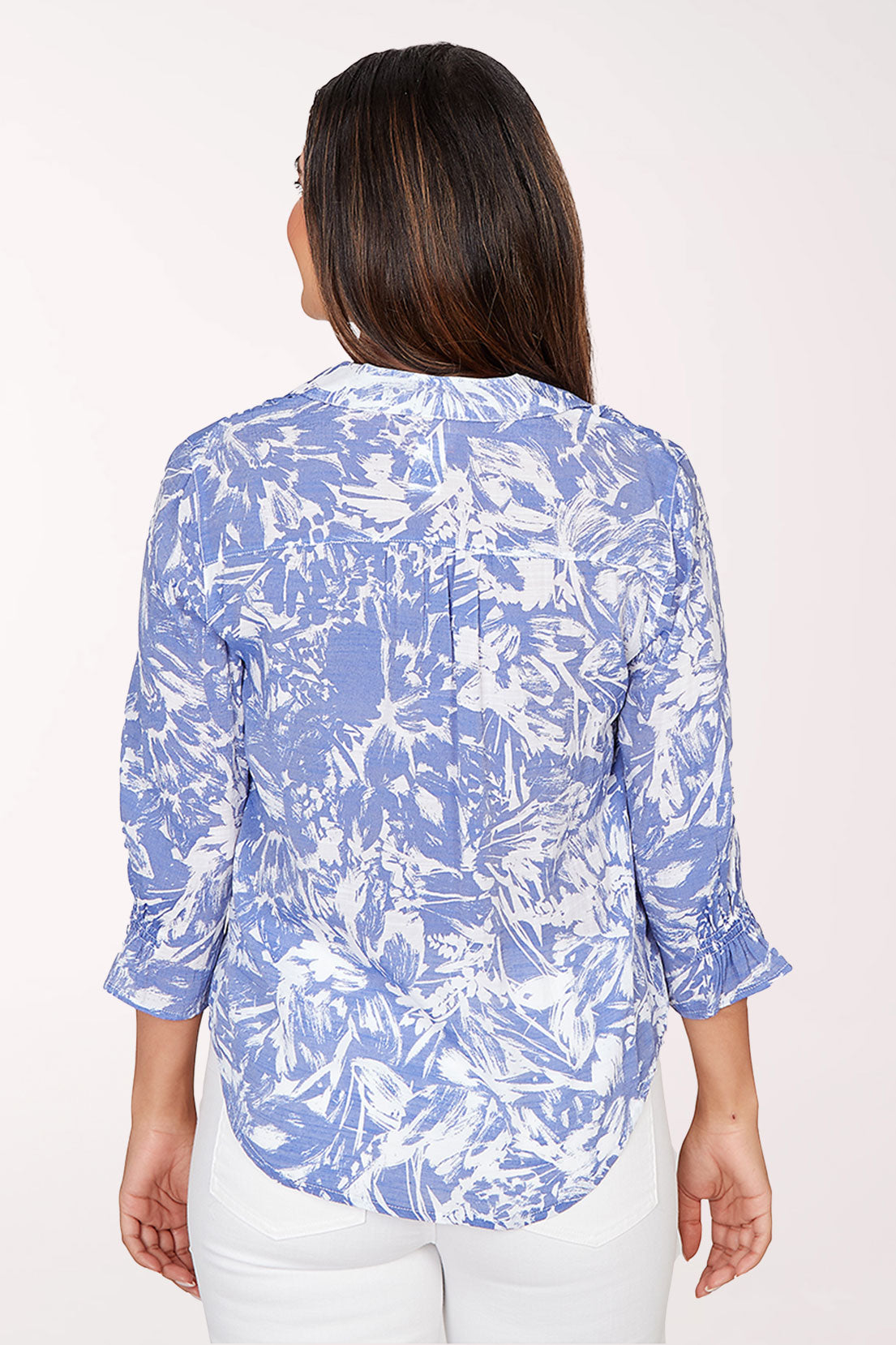 Woman wearing a blue and white patterned blouse on a white background