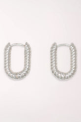 Pair of Periwinkle Silver Ribbed Huggie Hoop Earrings: rounded rectangular silver-tone huggie hoops with a diagonal ribbed, rope-like texture.