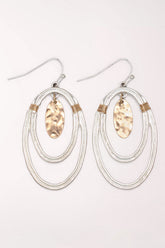 Pair of Periwinkle Silver and Gold Oval Drop Earrings on silver-tone French hooks: two nested hammered silver ovals with gold coil wraps at the top and a hammered gold oval disc dangling in the center.