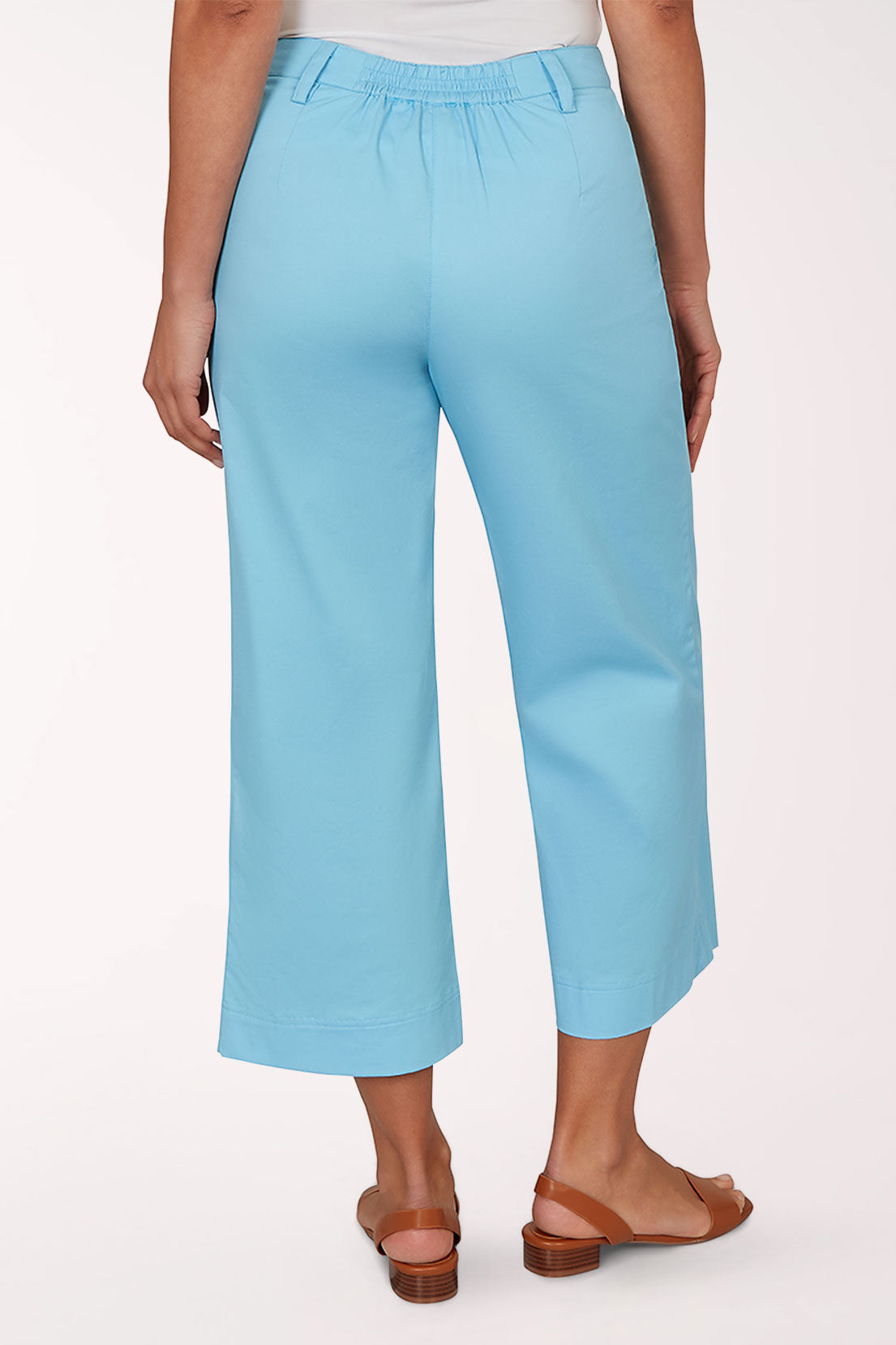 Person wearing light blue pants on a white background