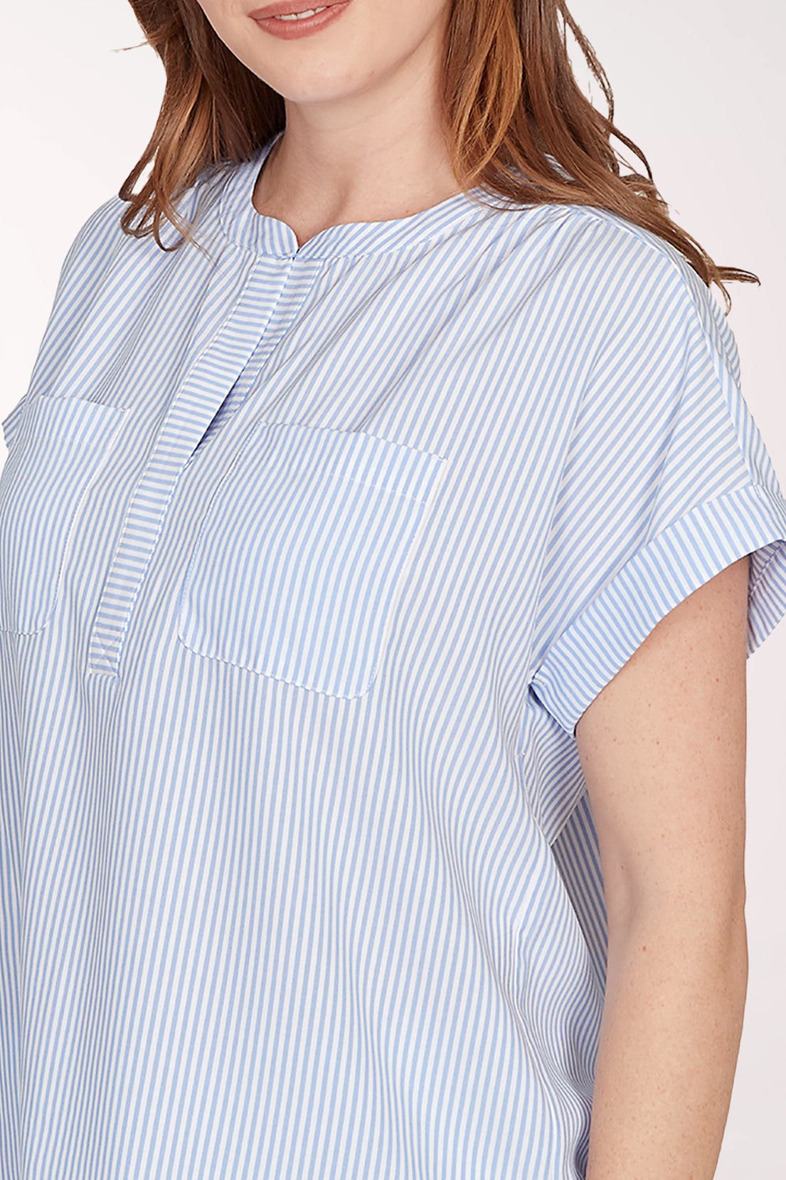 Woman wearing a blue and white striped shirt against a white background