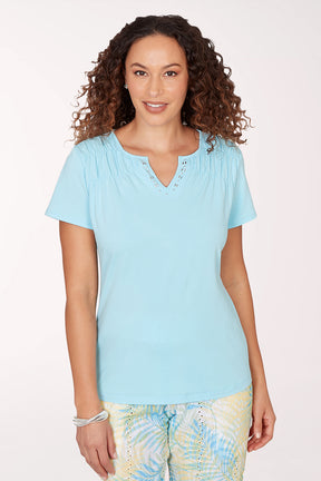 Woman wearing a light blue top with a white background