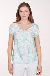 Woman wearing a light blue floral patterned top on a white background