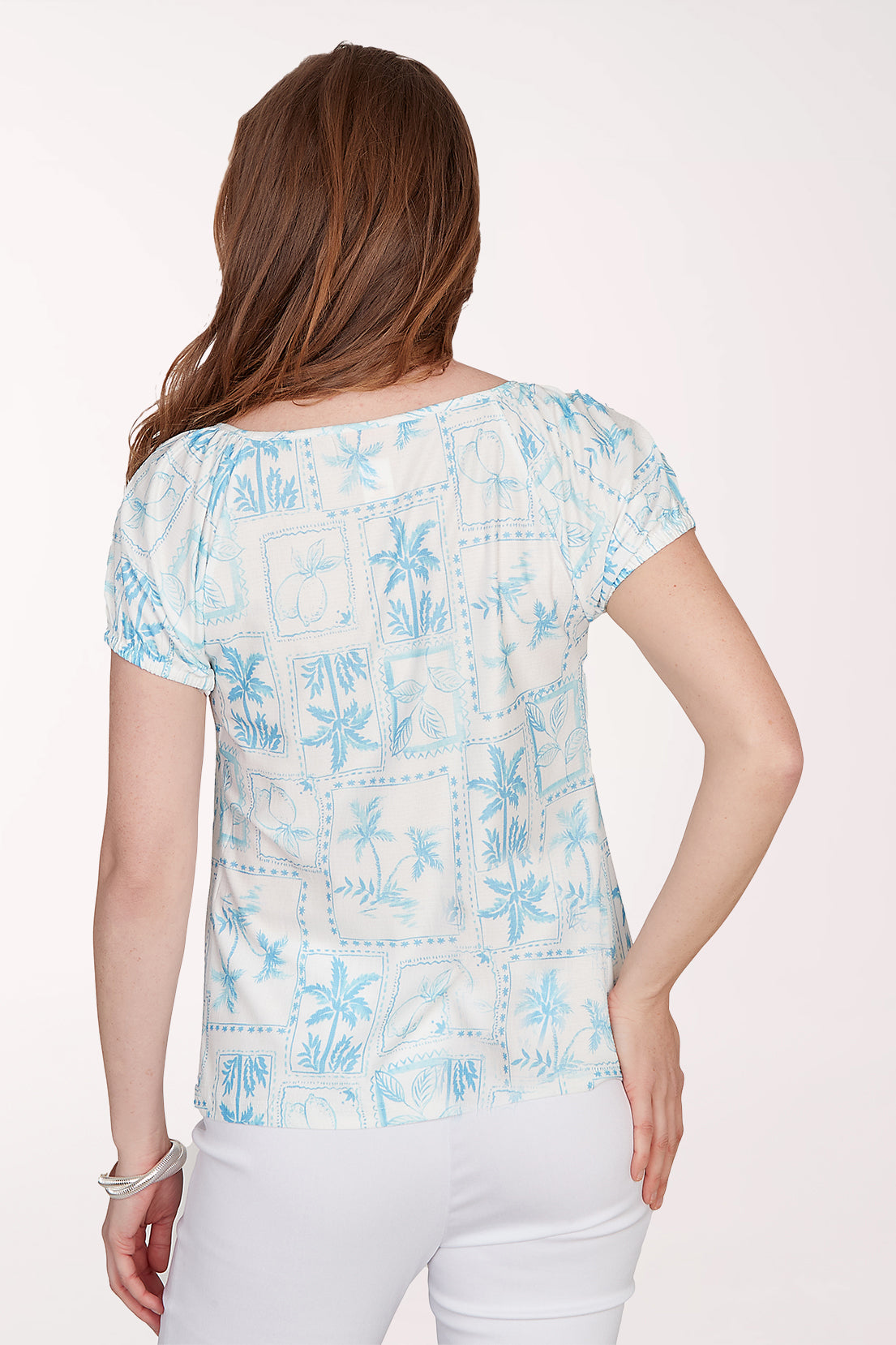 Woman wearing a light blue floral patterned top on a white background