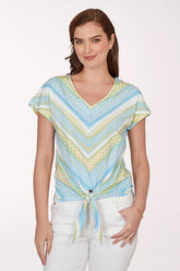 Woman wearing a colorful patterned top with a white background