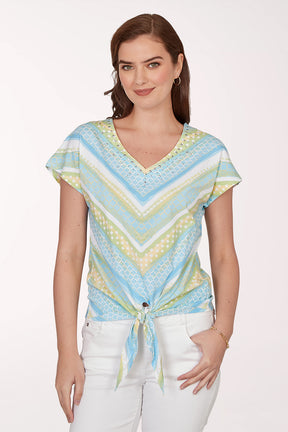 Woman wearing a colorful patterned top with a white background