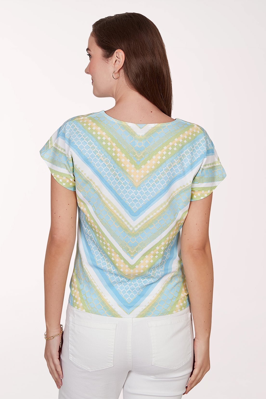Woman wearing a colorful patterned top with a white background