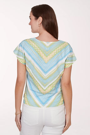 Woman wearing a colorful patterned top with a white background