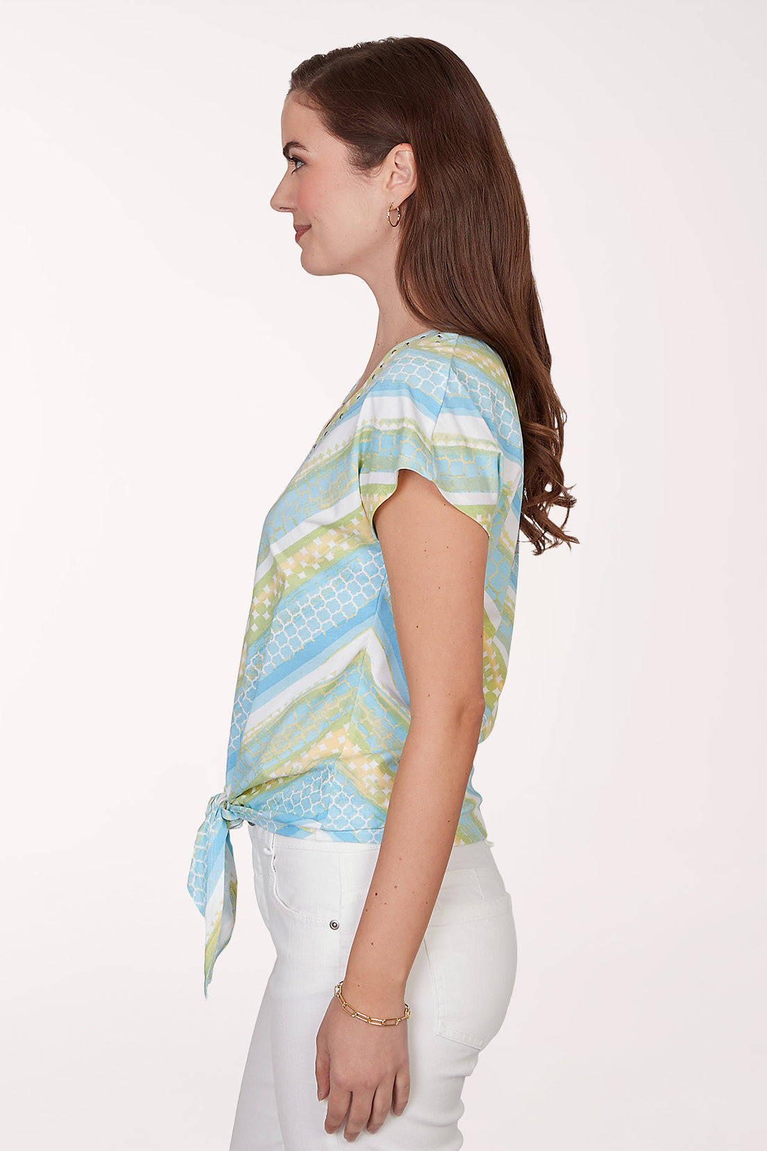 Woman wearing a colorful patterned top with a white background