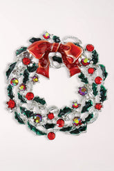 Periwinkle Classic Wreath Pin: a silver-tone wreath with green enamel holly leaves, red and iridescent crystals, and a red enamel bow at the top.
