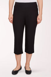 Person wearing black capri pants on a white background