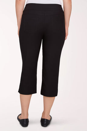 Person wearing black capri pants on a white background