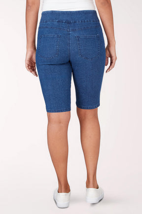 Blue denim shorts worn by a person on a white background