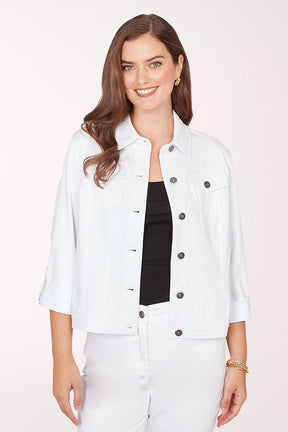 Woman wearing a white jacket with black buttons on a light pink background