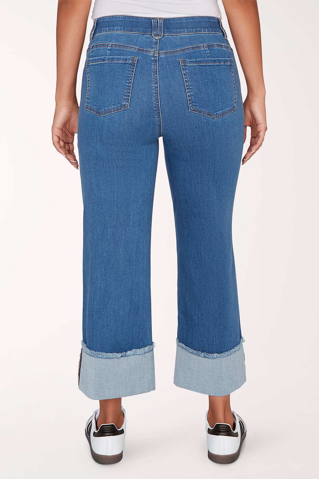 Person wearing blue jeans with a white background