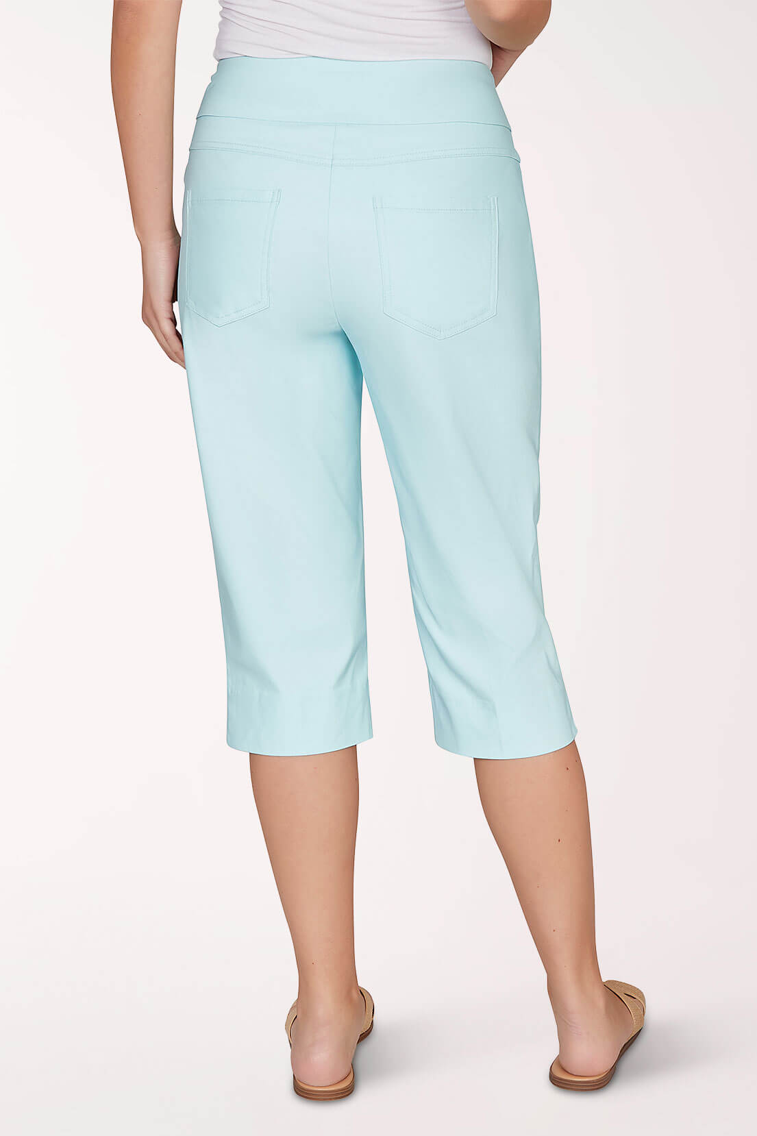 A light blue capri pant worn by a woman on a light pink background - back shot