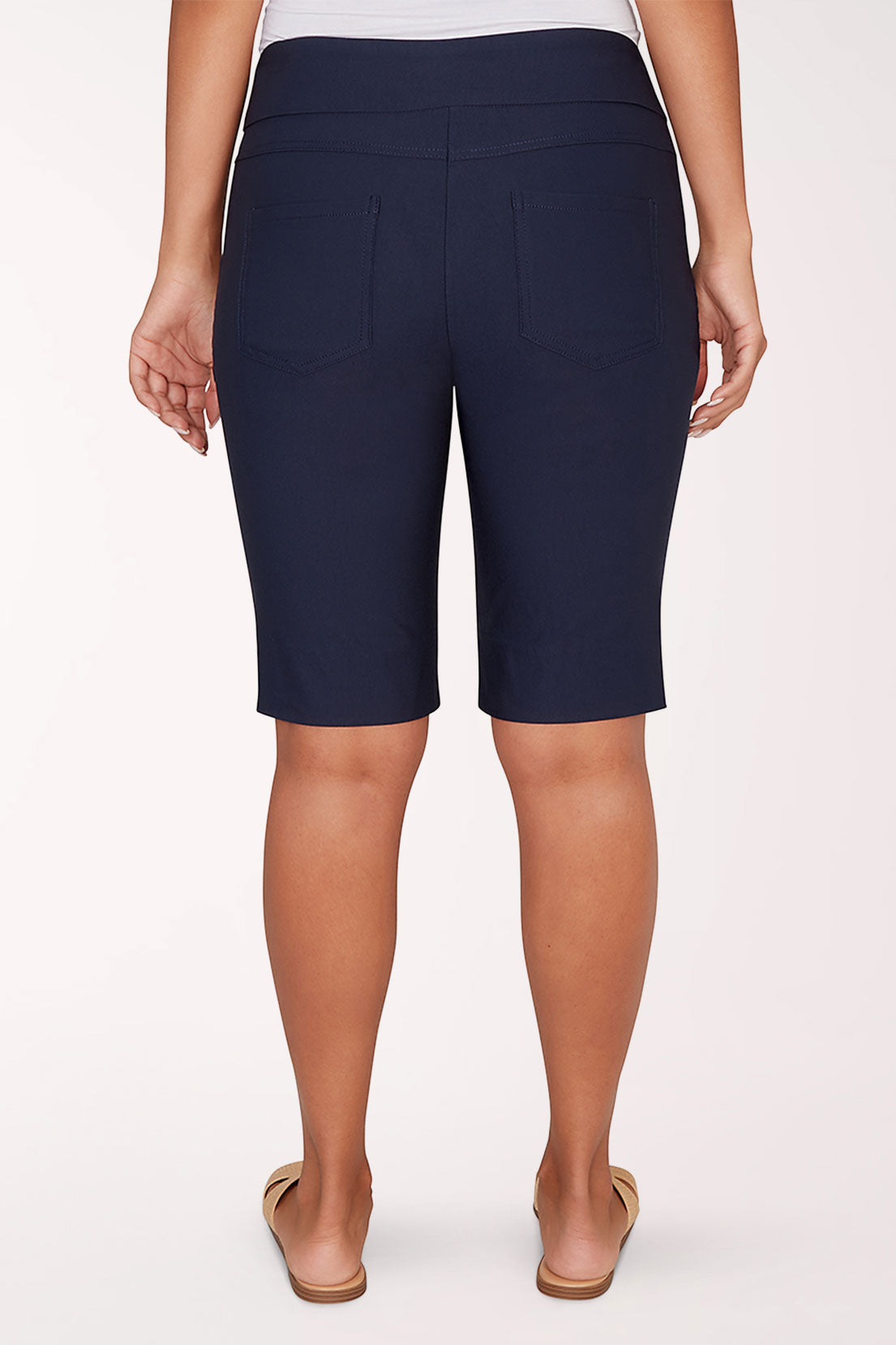 Person wearing navy blue shorts on a white background