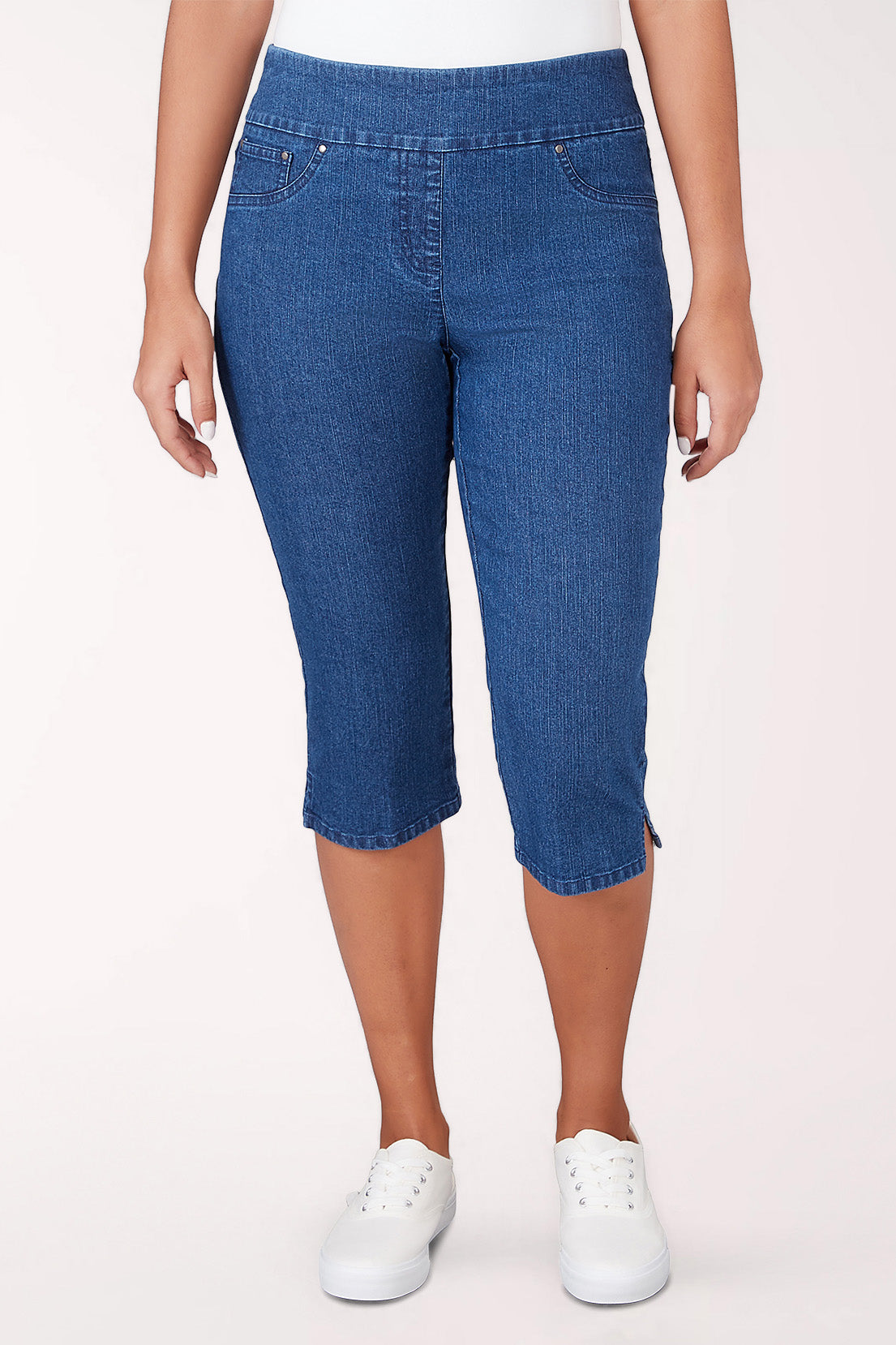 Person wearing blue denim capri pants on a white background