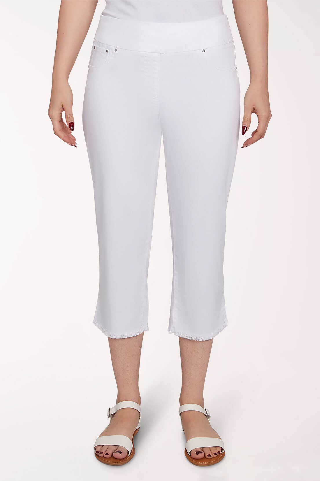 White capri pants worn by a person on a light pink background